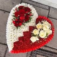 Handcrafted broken heart funeral floral tribute featuring a split red and white rose and carnation design.